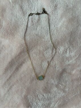 Short gold necklace with white stone